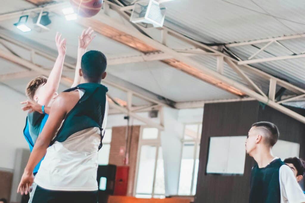 Male students playing basketball in the school's court